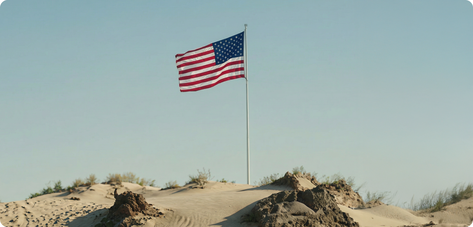 American flag above coastal dunes